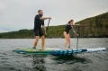 para na desce SUP Gladiator wykonuje skręt na fali podczas pływania na morzu.webp