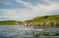 Pompowane deski SUP Gladiator Elite - grupa osób na wodzie ściga się_half.webp