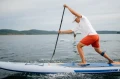Mężczyzna wiosłuje zawcięcie na desce SUP 14 Gladaitor Elite 2026_half.webp