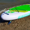 pompowana deska sup Gladiator Origin 10.8 SC – deska na kamienistej plaży, widoczny statecznik, zawór i linki bagażowe