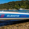sup Gladiator Origin 12.6T Rental – zdjęcie w plenerze, burta deski i logo Gladiator