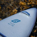 Deska SUP Gladiator Elite 14'0T – dziób deski z logo i kroplami wody, ujęcie przy kamieniach