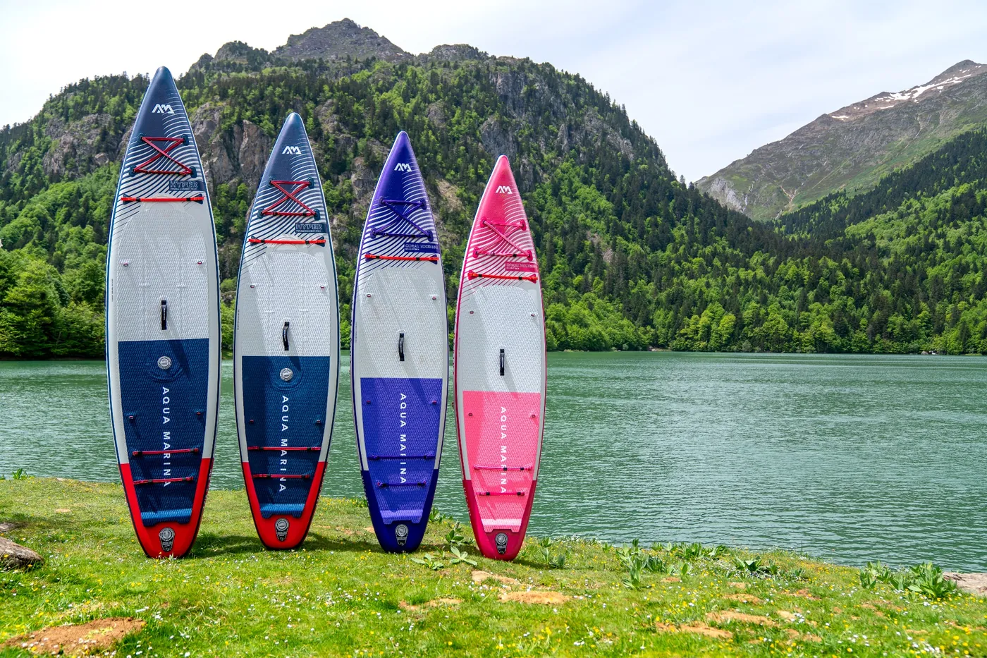 Deski SUP Aqua Marina touring o różnej długości ustawione nad górskim jeziorem – przykłady desek SUP do dłuższych wypraw