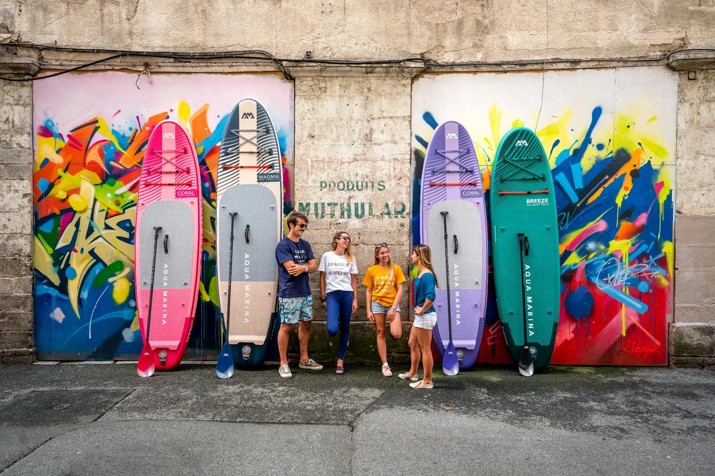 Porównanie rozmiarów desek SUP Aqua Marina – cztery modele SUP o różnej objętości i nośności stojące przy ścianie z graffiti