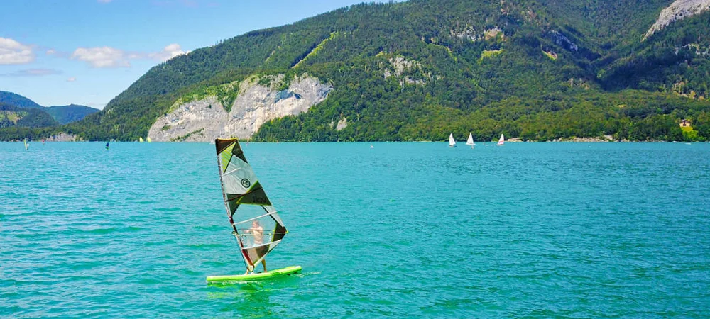 Dziecko pływające na windsurfingu na górskim jeziorze - artykuł w Activegames